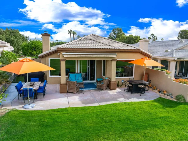 a view of a house with a yard and potted plants