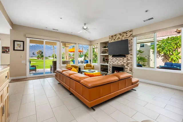 a living room with furniture a fireplace and a large window