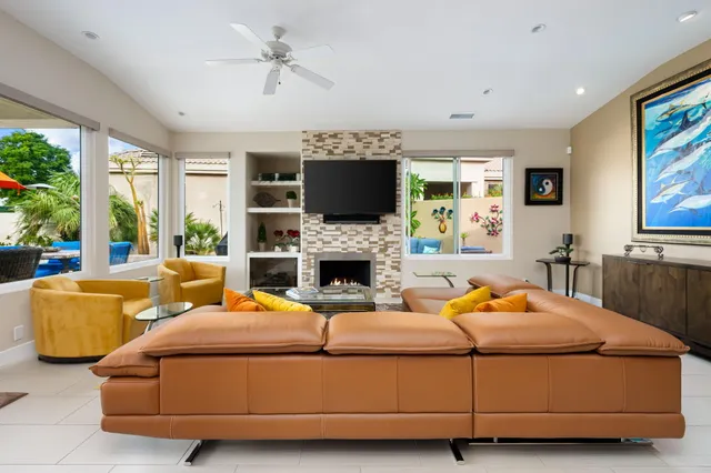 a living room with furniture fireplace and a large window