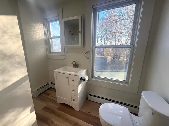 a bathroom with a toilet sink and mirror