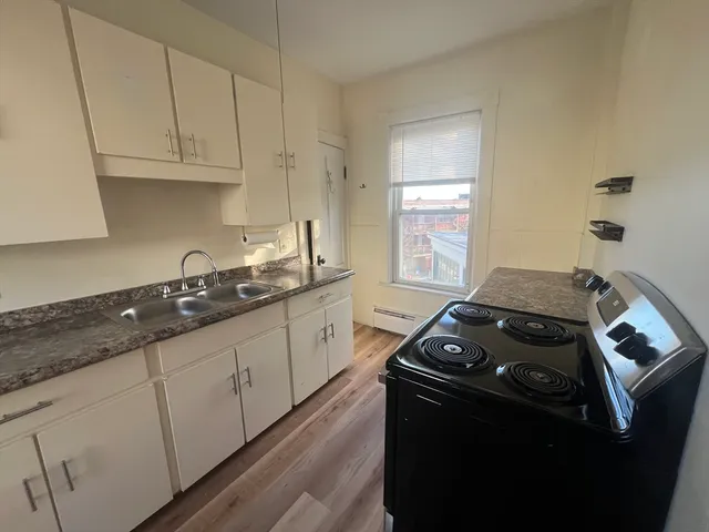 a kitchen with sink a stove and cabinets