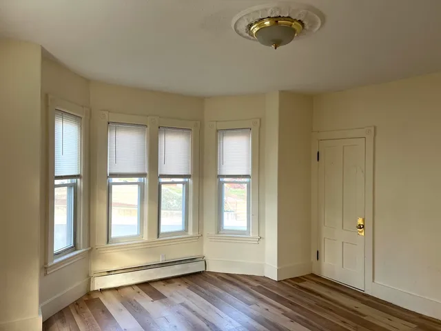 a view of room with window and wooden floor