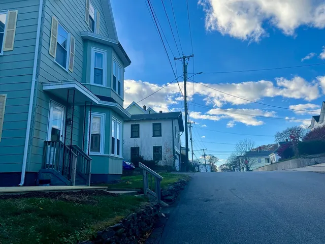 a view of a house with a yard and tree