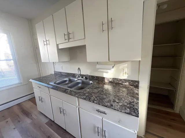 a kitchen with granite countertop a sink and a stove