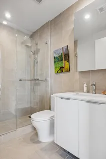 a bathroom with a sink a toilet and shower