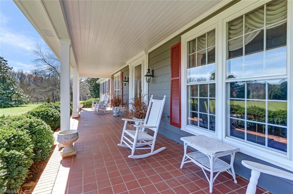 1760 Simpson Road Stokesdale, NC 27357 - Photo 8 of 30 Charming covered front porch provides sheltered views across the property. Tile floor, beadboard ceiling detail.