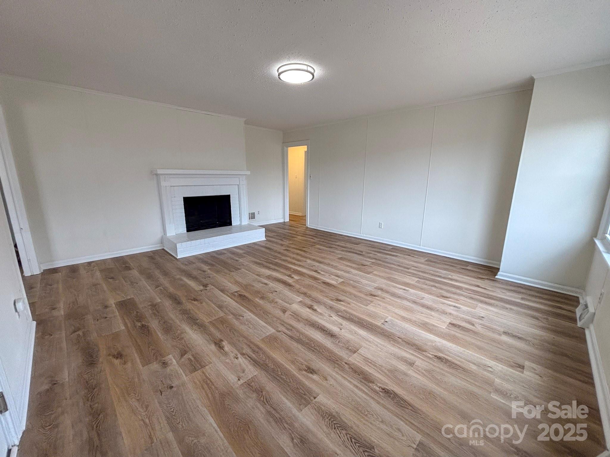 1117 Red Street Kannapolis, NC 28081 - Photo 3 of 48 a view of empty room with wooden floor and fireplace