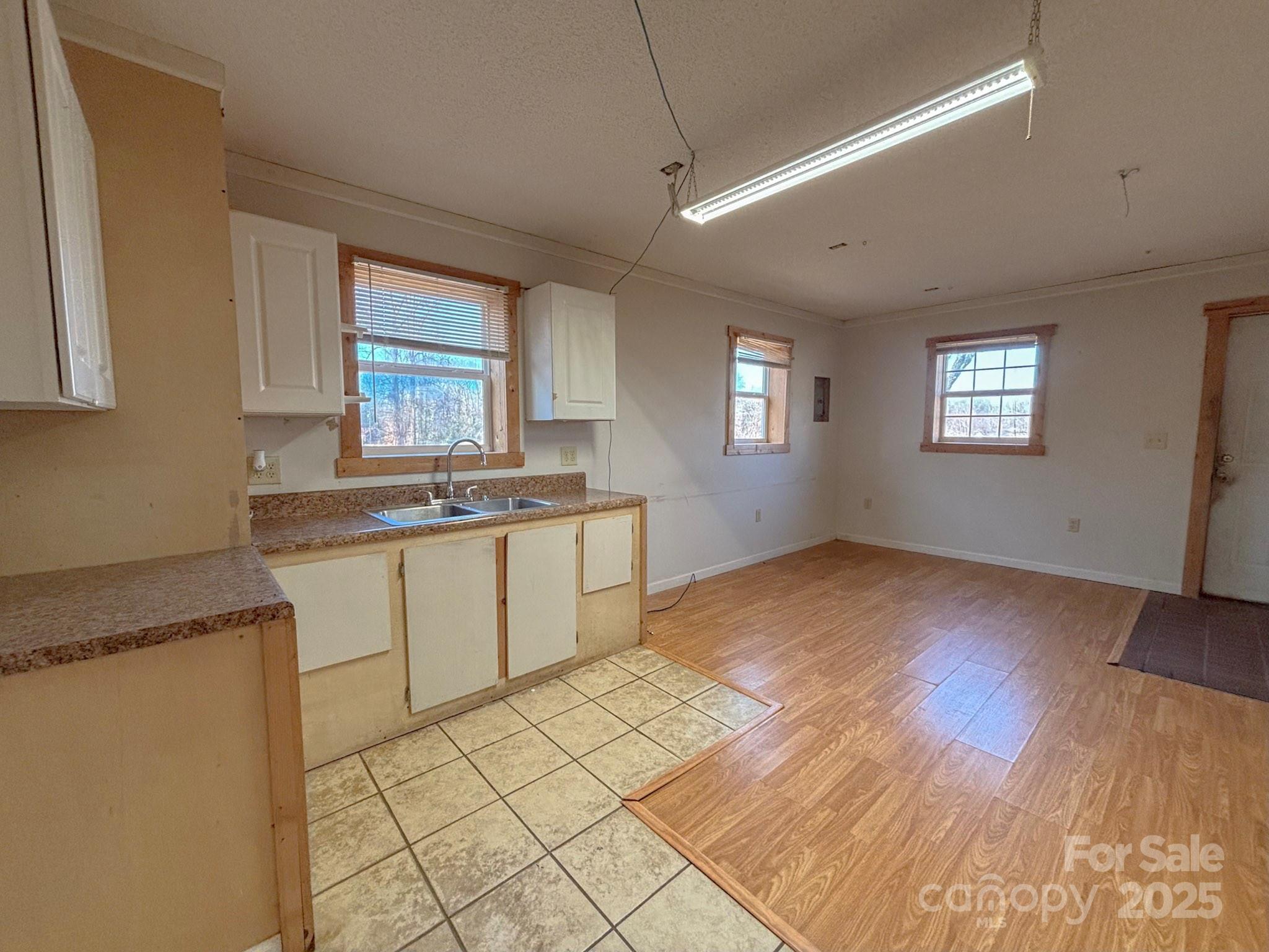 1117 Red Street Kannapolis, NC 28081 - Photo 37 of 48 a kitchen with granite countertop a stove a sink and white cabinets with wooden floor