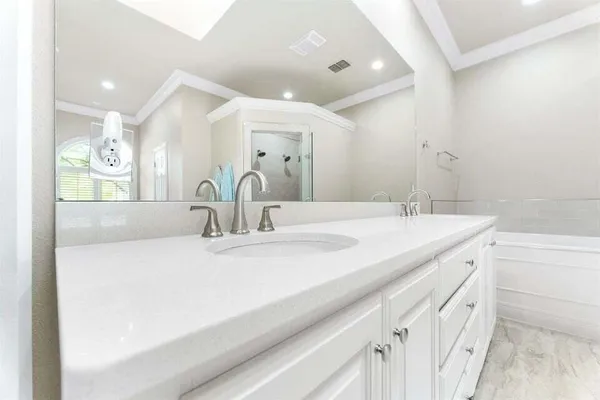 an empty room with wooden floor mirror and windows