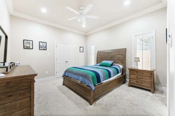 a bedroom with a bed lamp and a large window