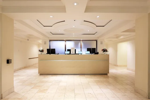 a living room with couches and kitchen view with wooden floor