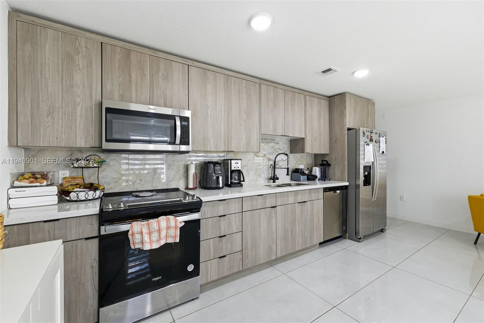 26122 Southwest 145th Court Homestead, FL 33033 - Photo 6 of 54 a kitchen with a sink a stove top oven and refrigerator
