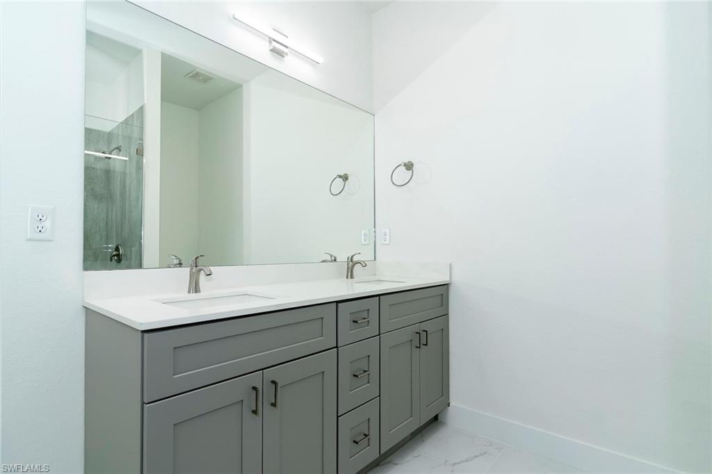 3810 29th Street Southwest Lehigh Acres, FL 33976 - Photo 18 of 48 a bathroom with a double vanity sink and mirror