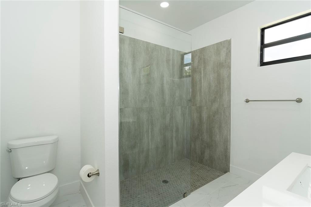 3810 29th Street Southwest Lehigh Acres, FL 33976 - Photo 21 of 48 a bathroom with a shower and a toilet