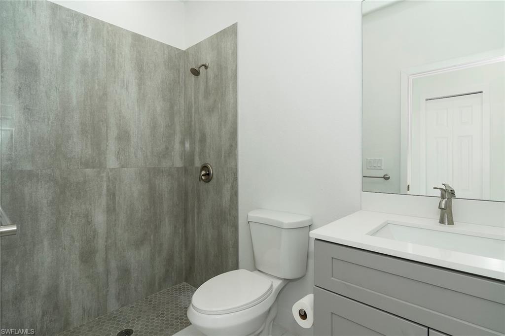 3810 29th Street Southwest Lehigh Acres, FL 33976 - Photo 42 of 48 a bathroom with a sink a toilet a shower and a mirror