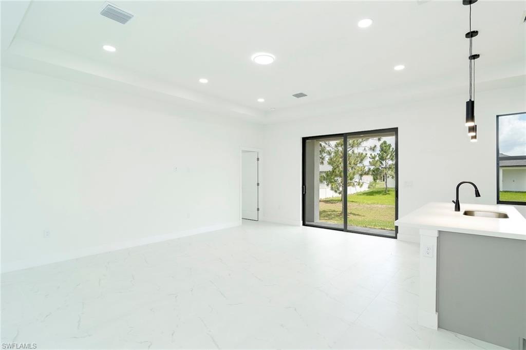 3810 29th Street Southwest Lehigh Acres, FL 33976 - Photo 5 of 48 a view of an empty room with a fireplace and a window