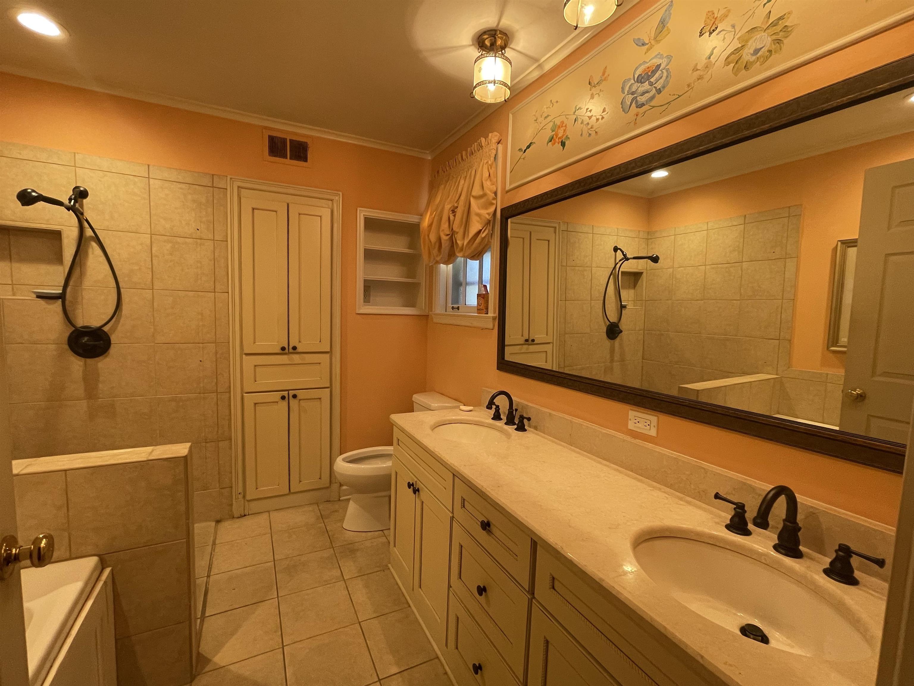4477 Tall Trees Drive Memphis, TN 38117 - Photo 14 of 25 a bathroom with a granite countertop sink a mirror and a shower