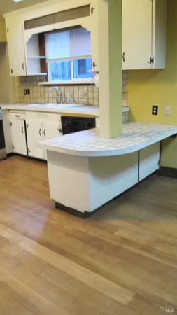 a view of kitchen cabinets and wooden floor