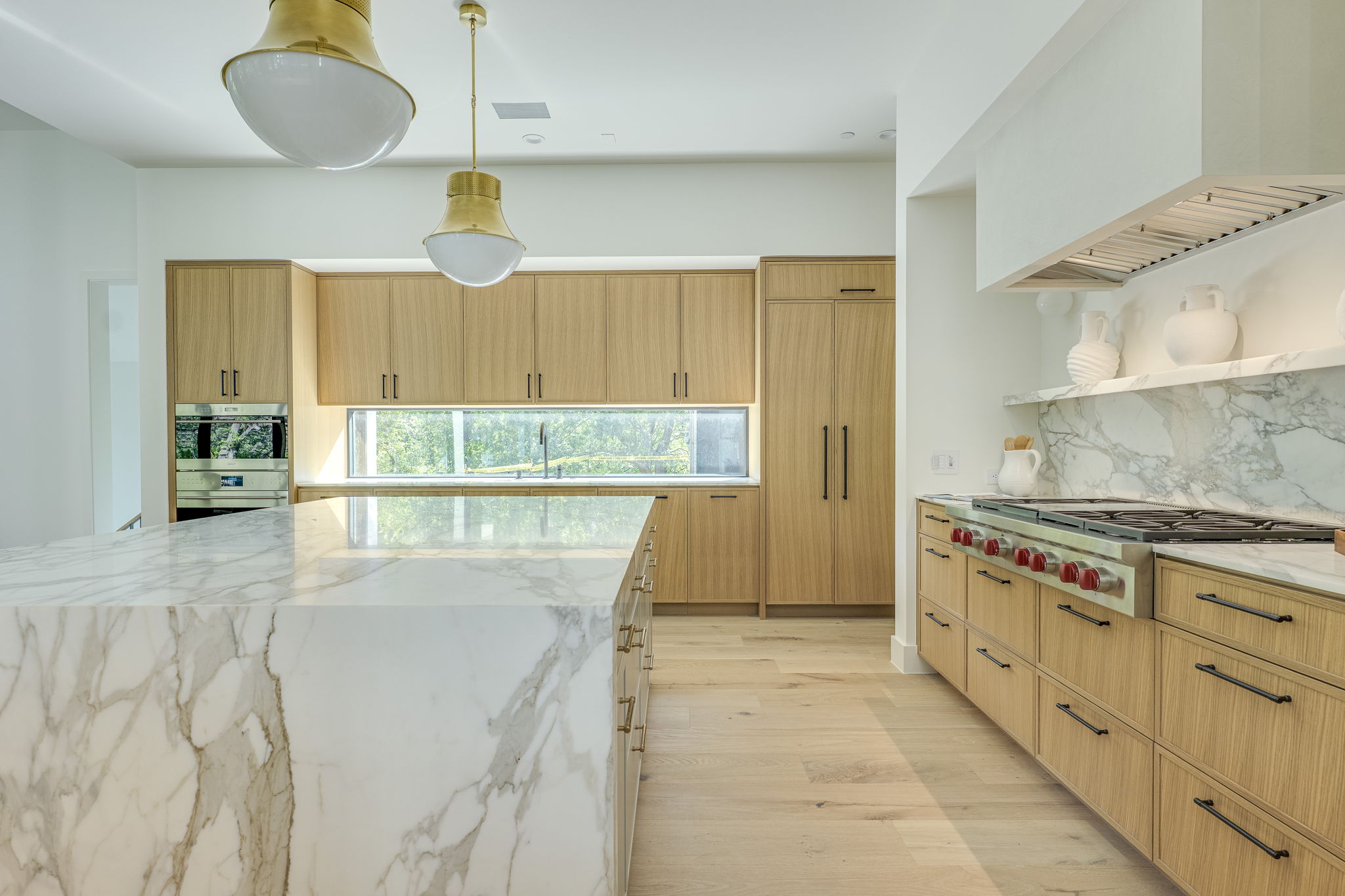 405 Honeycomb Ridge Austin, TX 78746 - Photo 5 of 15 Culinary excellence awaits in this kitchen featuring an expansive marble island and custom oak cabinetry.