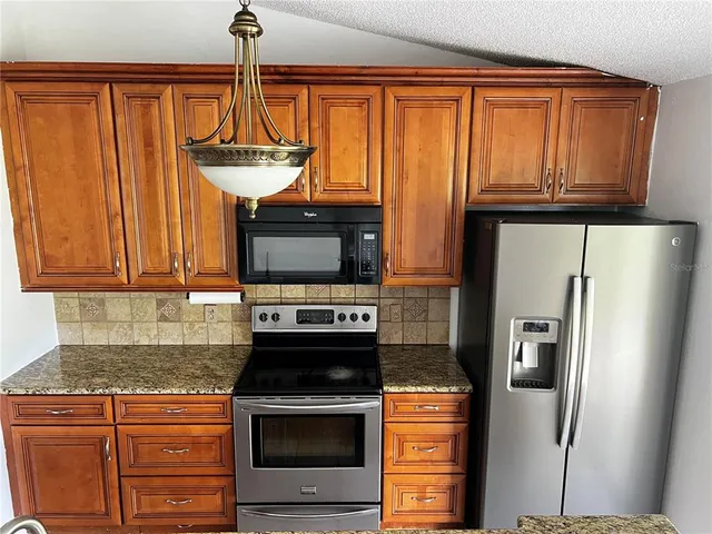 a kitchen with granite countertop a sink and a stove
