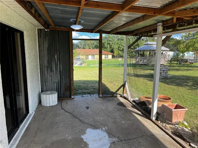a backyard of a house with table and chairs