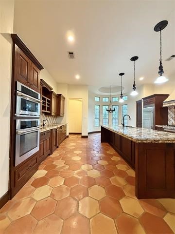 12410 Keith Road Beaumont, TX 77713 - Photo 9 of 45 a large kitchen with kitchen island granite countertop a large counter top and appliances