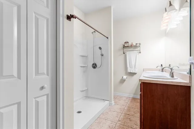 a bathroom with a granite countertop sink mirror and shower