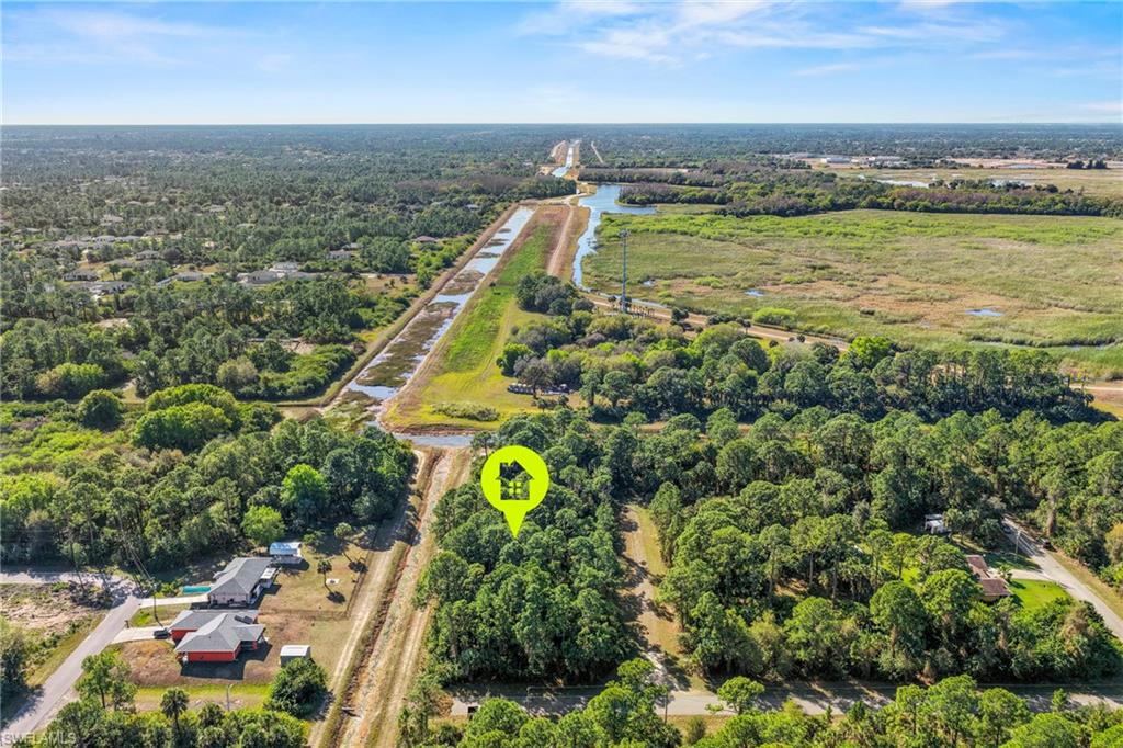 4702 Rita Avenue North Lehigh Acres, FL 33971 - Photo 11 of 15 an aerial view of a house with a garden and lake view