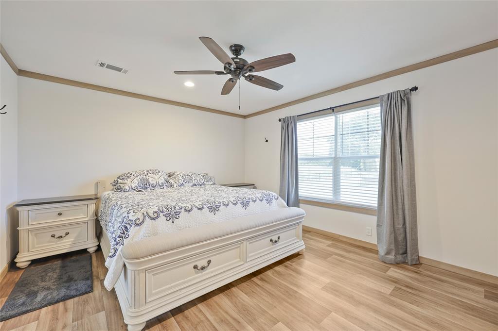 626 Epps Road Palmer, TX 75152 - Photo 20 of 27 Primary bedroom in 2nd home featuring wood-finish flooring, a window with blinds and drapes, a ceiling fan with integrated lighting, and crown molding