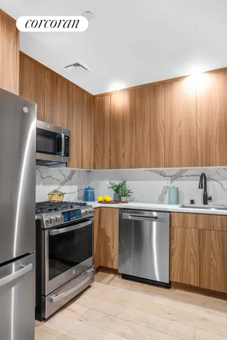 a kitchen with stainless steel appliances granite countertop a stove a sink and a microwave