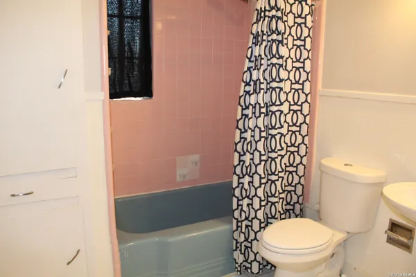 a white toilet sitting next to a shower curtain