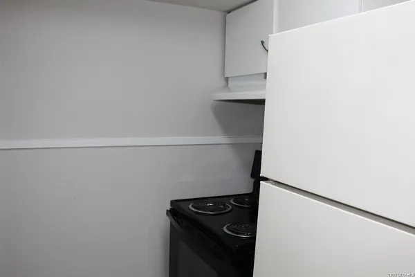a view of kitchen with refrigerator and white stove