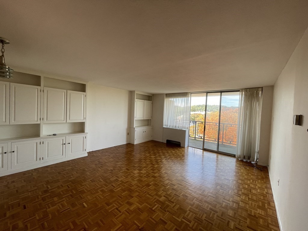 80 Salisbury Street, Unit 806 Worcester, MA 01609 - Photo 3 of 13 a view of an empty room with a window and wooden floor