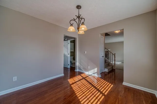 a view of a room with wooden floor staircase and a hallway