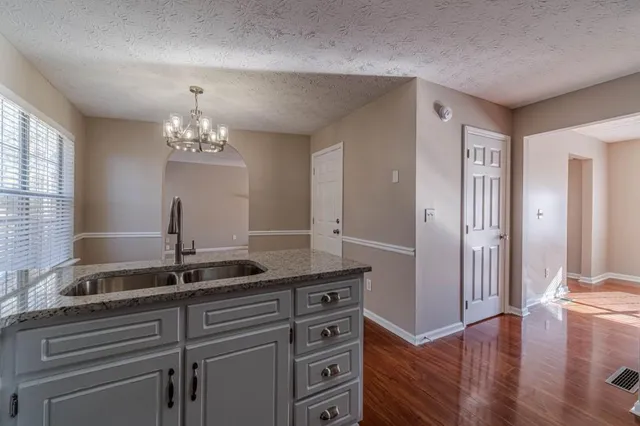 a kitchen with granite countertop a sink and cabinets