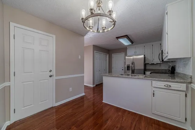 a kitchen with stainless steel appliances granite countertop a sink a stove and cabinets