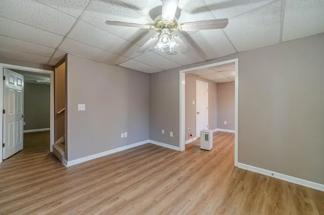 a view of an empty room with window and wooden floor