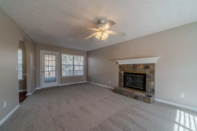 a view of an empty room with a fireplace and a window