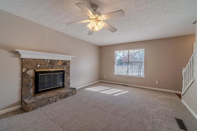 a living room with a fireplace and a ceiling fan