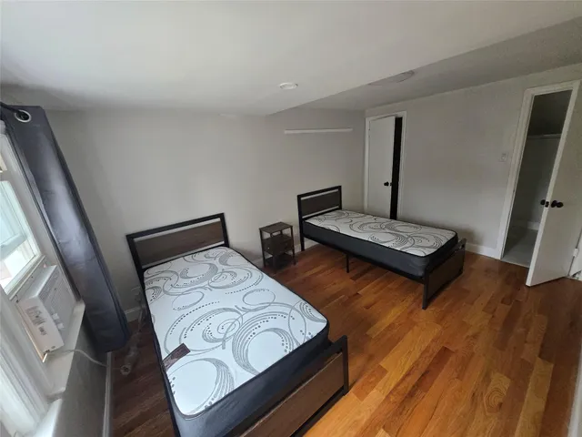 a bedroom with two beds and a large window