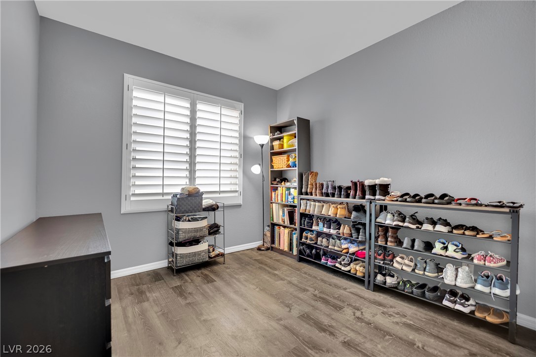 1724 Millstream Way Henderson, NV 89074 - Photo 23 of 60 Hardwood-style flooring and bright window with blinds create a versatile secondary bedroom space.