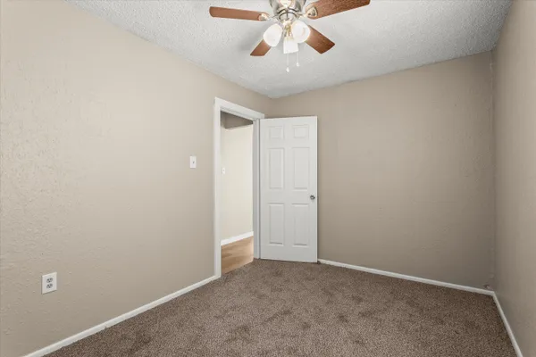 an empty room with chandelier fan
