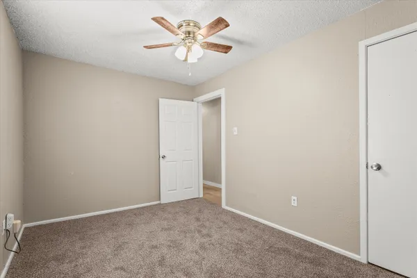 an empty room with a ceiling fan and a window