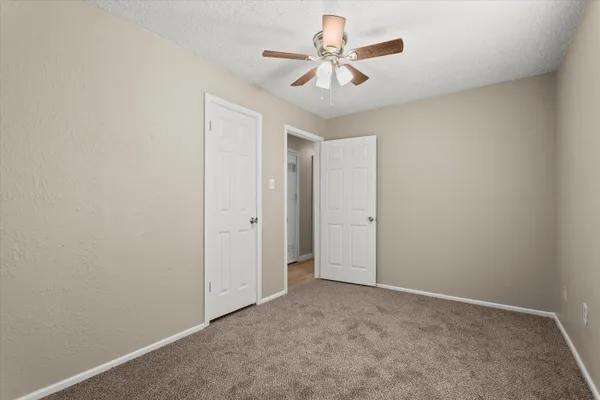 an empty room with a ceiling fan and a window