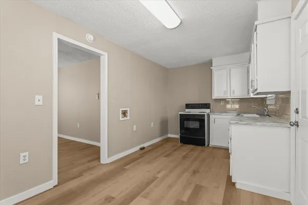 a kitchen with sink a microwave and cabinets