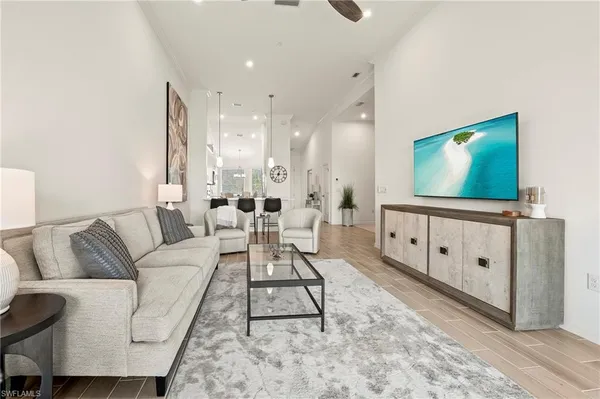 a living room with furniture a flat screen tv and a floor to ceiling window
