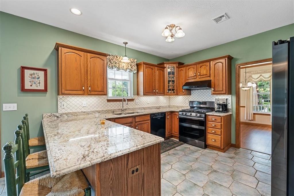 204 Salt Works Road Harmony, PA 16037 - Photo 10 of 35 a kitchen with stainless steel appliances granite countertop sink stove top oven and cabinets