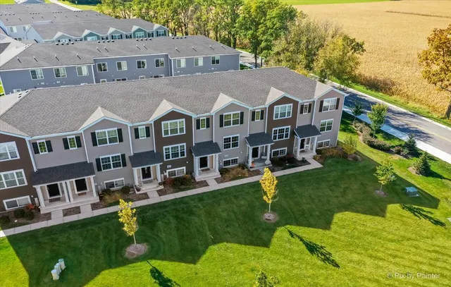 a aerial view of a brick house with a yard table and chairs
