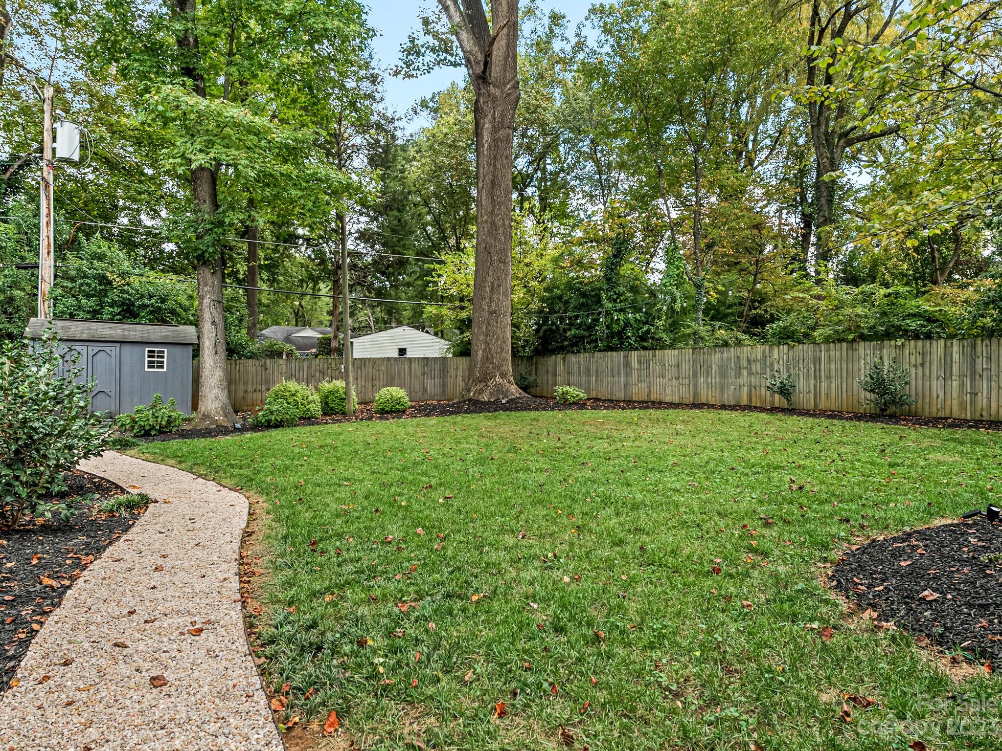 4601 Murrayhill Road Charlotte, NC 28209 - Photo 19 of 21 a view of a backyard with large trees and wooden fence