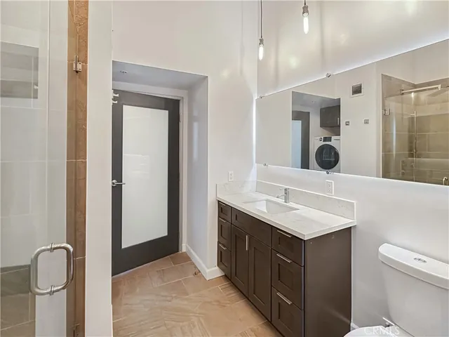 a bathroom with a sink a toilet and shower